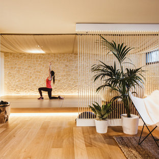 Foto di uno studio yoga mediterraneo con parquet chiaro, pareti beige e pavimento beige
