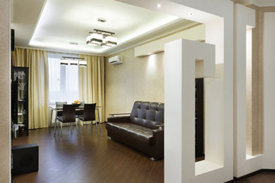 Свежая идея для дизайна: открытая гостиная комната среднего размера в современном стиле с бежевыми стенами, паркетным полом среднего тона, телевизором на стене и коричневым полом - отличное фото интерьера