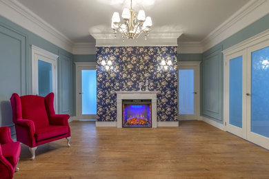 На фото: большая изолированная гостиная комната в современном стиле с синими стенами, полом из ламината, стандартным камином, фасадом камина из штукатурки и коричневым полом