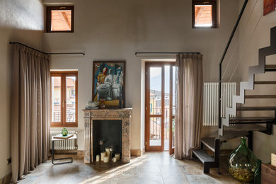 На фото: маленькая двухуровневая гостиная комната в средиземноморском стиле с полом из керамогранита, стандартным камином и телевизором на стене для на участке и в саду