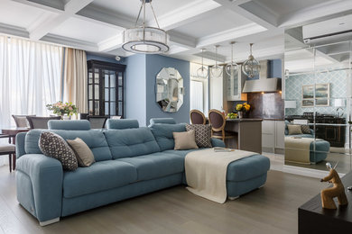На фото: гостиная комната в классическом стиле с синими стенами, светлым паркетным полом, бежевым полом и синим диваном