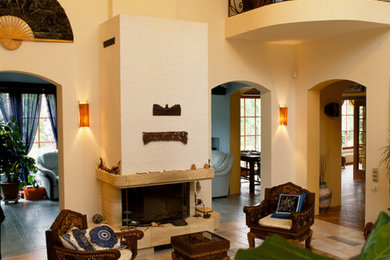 Источник вдохновения для домашнего уюта: открытая гостиная комната среднего размера в восточном стиле с желтыми стенами, полом из терракотовой плитки, стандартным камином и фасадом камина из камня без телевизора