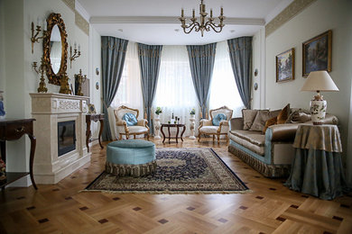 Пример оригинального дизайна: парадная гостиная комната в классическом стиле с светлым паркетным полом, стандартным камином и коричневым полом