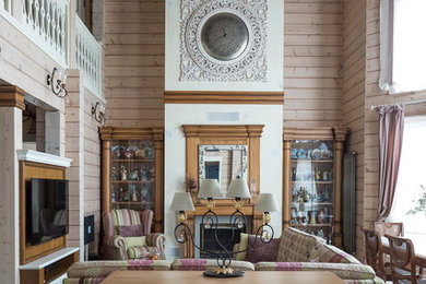 На фото: большая открытая гостиная комната в стиле фьюжн с полом из керамогранита, стандартным камином, фасадом камина из дерева и мультимедийным центром с