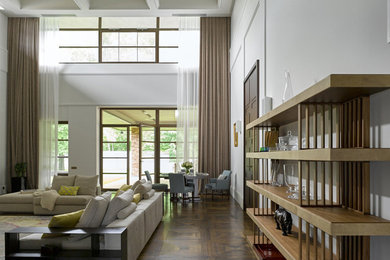 Пример оригинального дизайна: гостиная комната в современном стиле с белыми стенами, темным паркетным полом и коричневым полом