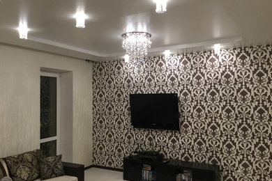 На фото: гостиная комната среднего размера в современном стиле с полом из ламината и телевизором на стене