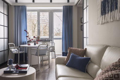 Esempio di un piccolo soggiorno contemporaneo aperto con pareti beige, pavimento in legno massello medio e pavimento marrone