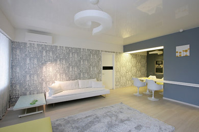 Diseño de salón abierto actual de tamaño medio con paredes grises y suelo de madera clara