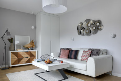 Imagen de salón cerrado contemporáneo con paredes grises y suelo de madera clara