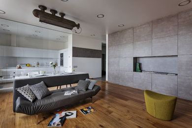 Foto de salón abierto urbano grande con chimenea lineal, suelo de madera en tonos medios, suelo marrón y paredes grises