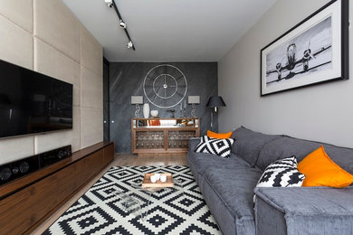 Источник вдохновения для домашнего уюта: изолированная гостиная комната в современном стиле с серыми стенами, светлым паркетным полом, телевизором на стене и акцентной стеной