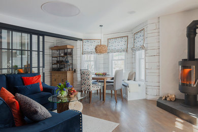 Immagine di un soggiorno chic con sala formale, pareti bianche, parquet chiaro, stufa a legna e pavimento marrone