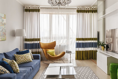 На фото: парадная гостиная комната в современном стиле с белыми стенами, светлым паркетным полом, отдельно стоящим телевизором и синим диваном