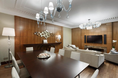 На фото: большая изолированная гостиная комната в современном стиле с коричневыми стенами, телевизором на стене и паркетным полом среднего тона с