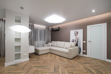 Идея дизайна: большая открытая гостиная комната в современном стиле с серыми стенами, полом из керамогранита, телевизором на стене и коричневым полом без камина
