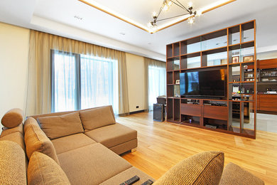 Идея дизайна: большая изолированная гостиная комната в современном стиле с бежевыми стенами, светлым паркетным полом, отдельно стоящим телевизором и коричневым полом
