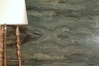 Cette image montre un salon design avec un mur vert, un sol en marbre et un manteau de cheminée en pierre.
