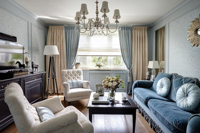 Diseño de sala de estar tradicional sin chimenea con paredes azules y suelo de madera en tonos medios