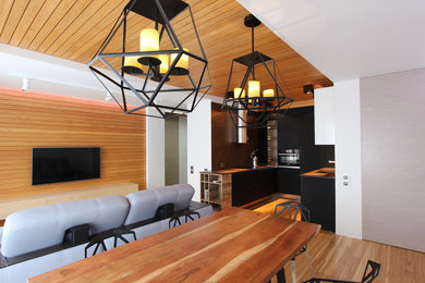 Стильный дизайн: парадная, открытая гостиная комната в современном стиле с разноцветными стенами, светлым паркетным полом и телевизором на стене - последний тренд