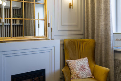 Свежая идея для дизайна: маленькая открытая гостиная комната в современном стиле с серыми стенами, полом из ламината, стандартным камином, фасадом камина из штукатурки и коричневым полом без телевизора для на участке и в саду - отличное фото интерьера