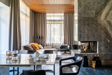 Aménagement d'un grand salon contemporain ouvert avec un mur blanc, un sol en marbre, une cheminée double-face, un manteau de cheminée en pierre, un téléviseur dissimulé et un sol bleu.