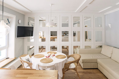 Imagen de salón abierto nórdico con suelo de madera en tonos medios y televisor colgado en la pared