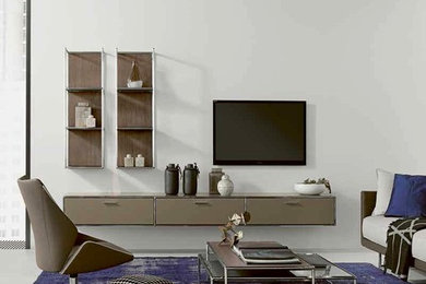Стильный дизайн: открытая гостиная комната среднего размера в современном стиле с с книжными шкафами и полками, серыми стенами, бетонным полом, телевизором на стене и серым полом - последний тренд