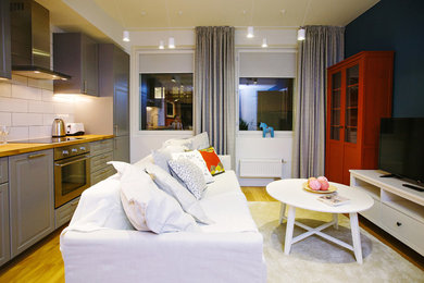 Источник вдохновения для домашнего уюта: объединенная гостиная комната среднего размера в современном стиле с синими стенами, полом из ламината, отдельно стоящим телевизором и бежевым полом