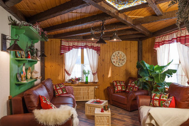 Modelo de salón abierto de estilo de casa de campo pequeño con paredes beige, suelo de corcho, todas las chimeneas, marco de chimenea de ladrillo y televisor colgado en la pared