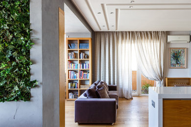 На фото: открытая, объединенная гостиная комната среднего размера в современном стиле с с книжными шкафами и полками, белыми стенами, светлым паркетным полом и бежевым полом с