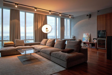 Imagen de salón abierto actual de tamaño medio con paredes grises, suelo de madera oscura y suelo marrón