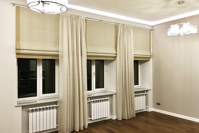 На фото: гостиная комната среднего размера в стиле неоклассика (современная классика) с серыми стенами и тюлем на окнах с