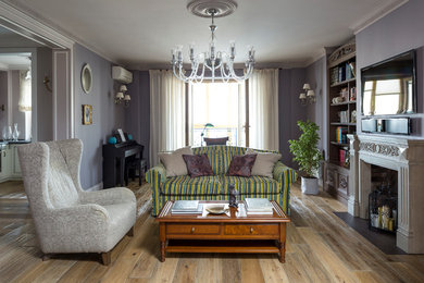 Ejemplo de salón para visitas clásico con paredes púrpuras, suelo de madera en tonos medios, todas las chimeneas y televisor colgado en la pared