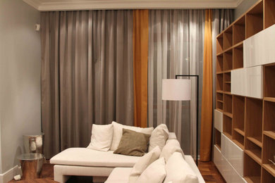 Пример оригинального дизайна: открытая гостиная комната в современном стиле с с книжными шкафами и полками, серыми стенами и паркетным полом среднего тона