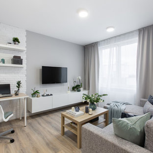 Idéer för att renovera ett litet funkis allrum med öppen planlösning, med grå väggar, laminatgolv, en väggmonterad TV och beiget golv
