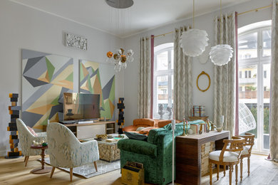 Пример оригинального дизайна: открытая гостиная комната в стиле фьюжн с светлым паркетным полом, отдельно стоящим телевизором, серыми стенами и бежевым полом