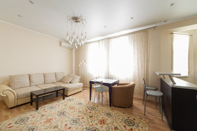 Foto de salón cerrado tradicional renovado de tamaño medio sin chimenea y televisor con paredes beige, suelo laminado y suelo beige
