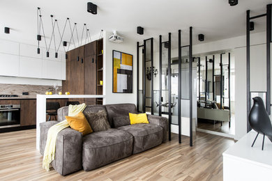 Ejemplo de salón abierto contemporáneo con paredes blancas, suelo de madera clara y suelo beige
