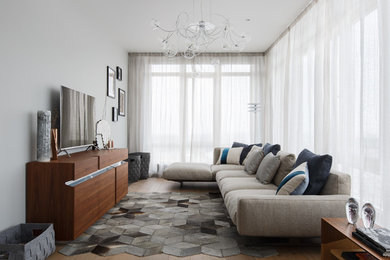 Источник вдохновения для домашнего уюта: большая гостиная комната в современном стиле с паркетным полом среднего тона, отдельно стоящим телевизором и серыми стенами без камина