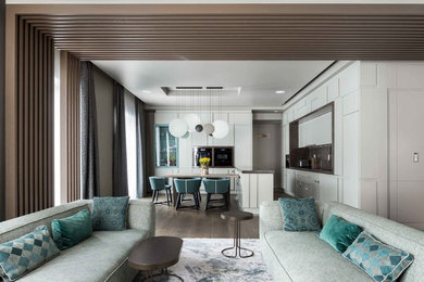 Diseño de salón abierto actual grande con paredes grises, suelo de madera en tonos medios y suelo gris
