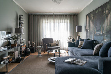 Пример оригинального дизайна: изолированная гостиная комната среднего размера в современном стиле с зелеными стенами, паркетным полом среднего тона, телевизором на стене, коричневым полом и фасадом камина из дерева