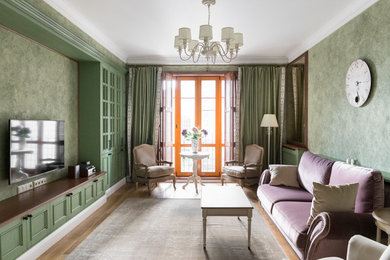 Ejemplo de salón tradicional renovado con paredes verdes, televisor colgado en la pared y suelo marrón