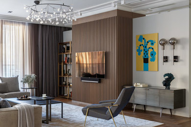На фото: гостиная комната в стиле модернизм с белыми стенами, паркетным полом среднего тона, телевизором на стене и коричневым полом