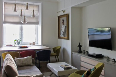Источник вдохновения для домашнего уюта: изолированная гостиная комната в современном стиле с серыми стенами, паркетным полом среднего тона и телевизором на стене