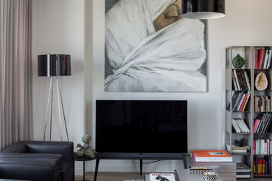 Пример оригинального дизайна: большая открытая гостиная комната в современном стиле с белыми стенами, полом из керамогранита, отдельно стоящим телевизором и серым полом