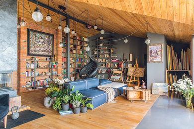 На фото: изолированная гостиная комната в стиле лофт с с книжными шкафами и полками, паркетным полом среднего тона, разноцветными стенами, разноцветным полом и синим диваном