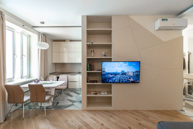 Diseño de salón abierto actual con paredes beige, suelo de madera clara y suelo beige