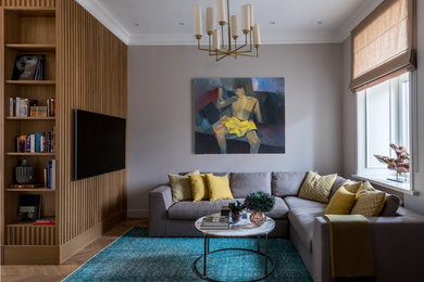 Ejemplo de salón abierto clásico renovado de tamaño medio sin chimenea con paredes grises, suelo de madera en tonos medios, televisor colgado en la pared y suelo marrón