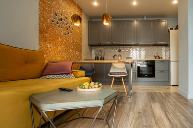 Стильный дизайн: маленькая гостиная комната в скандинавском стиле с синими стенами, полом из ламината и телевизором на стене для на участке и в саду - последний тренд