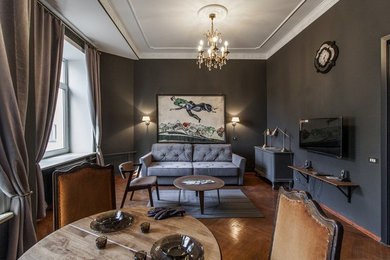 На фото: гостиная комната в стиле неоклассика (современная классика) с черными стенами, паркетным полом среднего тона и коричневым полом